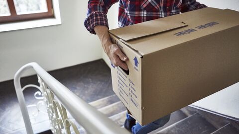 Umzugskiste das Treppenhaus hochtragen