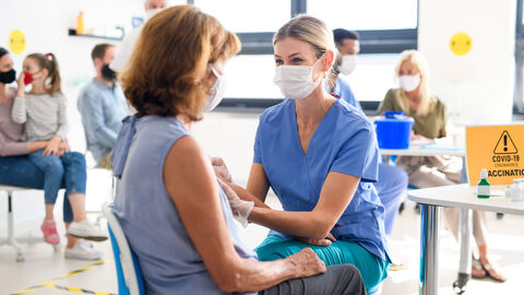 Junge Frau impft andere Frau Junge Frau impft andere Frau