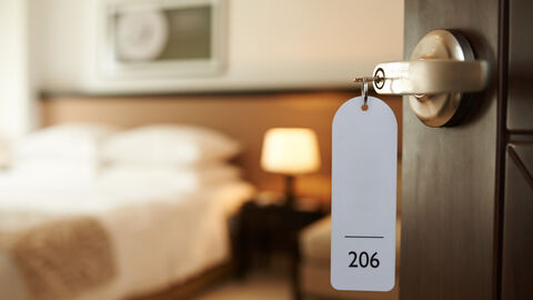 Blick in ein Hotelzimmer mit Schlüssel im Schloss Blick in ein Hotelzimmer mit Schlüssel im Schloss