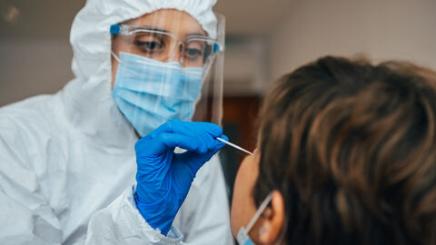 Fachpersonal testet Person mit Antigen-Schnelltest Fachpersonal testet Person mit Antigen-Schnelltest