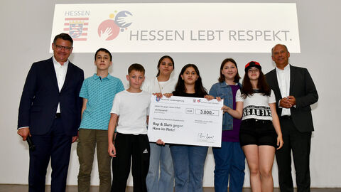 Ministerpräsident Boris Rhein hat im Landesmuseum Wiesbaden die Carl-Schomburg-Schule aus Kassel als Sieger des Schülerwettbewerbs gekürt. Ministerpräsident Rhein und Justizminister Poseck mit Schülerinnen und Schülern der Gewinnerschule.