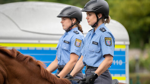 Zwei berittene Polizistinnen der Polizeireiterstaffel Frankfurt bei einem Besuch von Ministerpräsident Rhein bei Hessens einziger berittener Polizeieinheit in Frankfurt Zwei berittene Polizistinnen, jeweils auf einem Pferd sitzend, von der Seite fotografiert