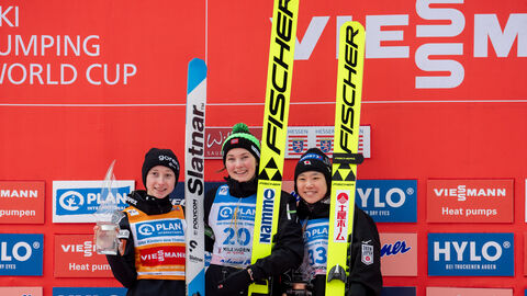 Damenspringen Siegerinnen Siegerinnen des Damen-Springen stehen auf Siegertreppe, halten Pokale uns Ski