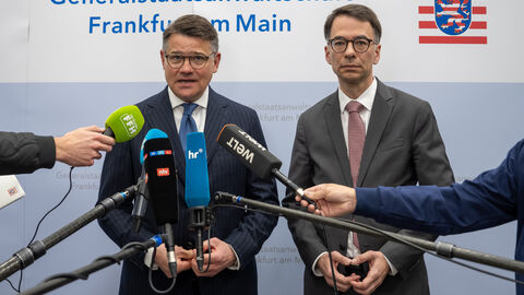 Zwei Männer stehen vor mehreren Mikrofonen und geben ein Statement ab