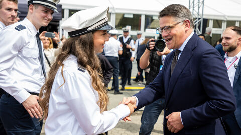 Ministerpräsident Boris Rhein schüttelt die Hand einer Frau.