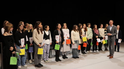 Gewinnerinnen und Gewinner des Schreibwettberwerbs Mehre Kinder auf einer Bühne