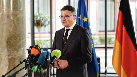 Ministerpräsident Boris Rhein im Interview vor dem Rüstungsgipfel. Ministerpräsident Rhein steht vor Mikrofonen in einer Interviewsituation.