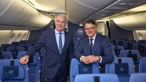 Ministerpräsident Boris Rhein und Lufthansa-Vorstandsvorsitzender Carsten Spohr im Passagierraum der Lufthansa-Maschine „Frankfurt am Main“. Zwei Männer stehen im Passagierbereich des Flugzeugs.