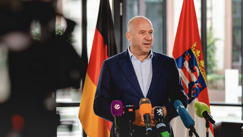 Umweltminister Ingmar Jung im Interview vor dem Rüstungsgipfel. Umweltminister Ingmar Jung steht vor Mikrofonen in einer Interviewsituation.