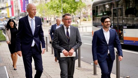 Herr Rhein, Herr Mansoori und Herr Schwarz laufen nebeneinander auf einem Bürgersteig