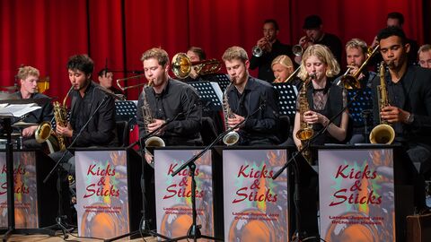 Das Landesjugendjazzorchester Kicks and Sticks in vollem Gange Das Landesjugendjazzorchester Kicks and Sticks wie es auf der Bühne am musizieren ist