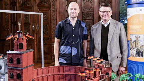 Ministerpräsident Boris Rhein eröffnet in Schloss Philippsruhe eine PLAYMOBIL-Ausstellung zur deutschen Demokratiegeschichte Ministerpräsident Boris Rhein eröffnet die PLAYMOBIL-Ausstellung „175 Jahre Paulskirche“ in Schloss Philippsruhe. Gemeinsam mit dem PLAYMOBIL-Künstler Oliver Schaffer steht er vor dem Diorama der Paulskirche.