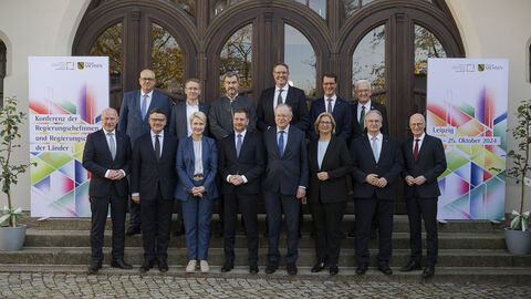 Regierungschefinnen und Regierungschefs der Länder 14 Männer und Frauen stehen in 2 Reihen vor einem Gebäude.