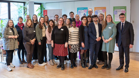 Mehrere Personen blicken in Kamera.