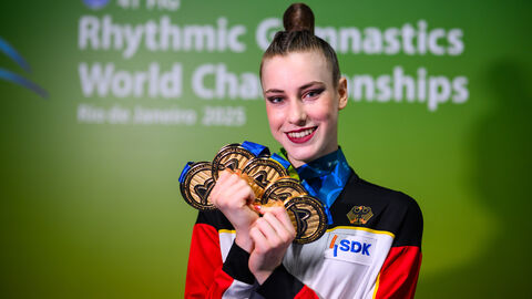 Frau hält fünf Goldmedaillen in den Händen